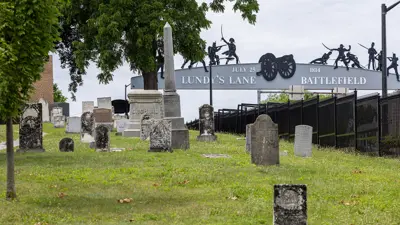 Lundy's Lane Battlefield archway crossing the road in the background, with cemetery monuments in the foreground.