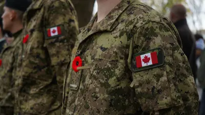 Close up people in military uniforms with a poppy on them and a Canadian Flag on the left arm side.