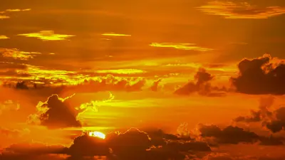 A hazy orange hot sky with the sun showing through.