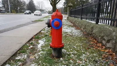 City of Niagara Falls fire hydrant in the boulevard next to Fairview Cemetery.  Showing the street and cars in the background.