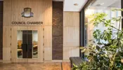 Wooden entrance doors of the City of Niagara Falls Council Chambers. With the City crest and the "Council Chamber" sign in black letters above the doors.