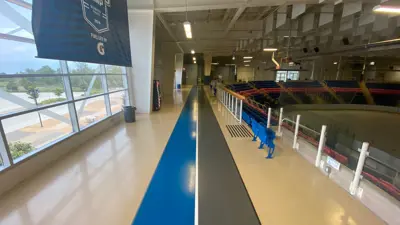 The indoor track at the Gale Centre in Niagara Falls. On the upper level going around the rink are two lanes, coloured blue and grey.