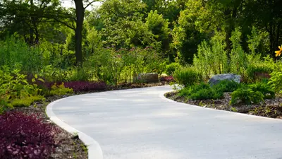 Path winding around gardens, greenery, and landscape rocks.