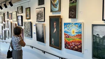 A woman looking at art exhibited on the wall of the Niagara Falls Exchange in Niagara Falls Ontario.